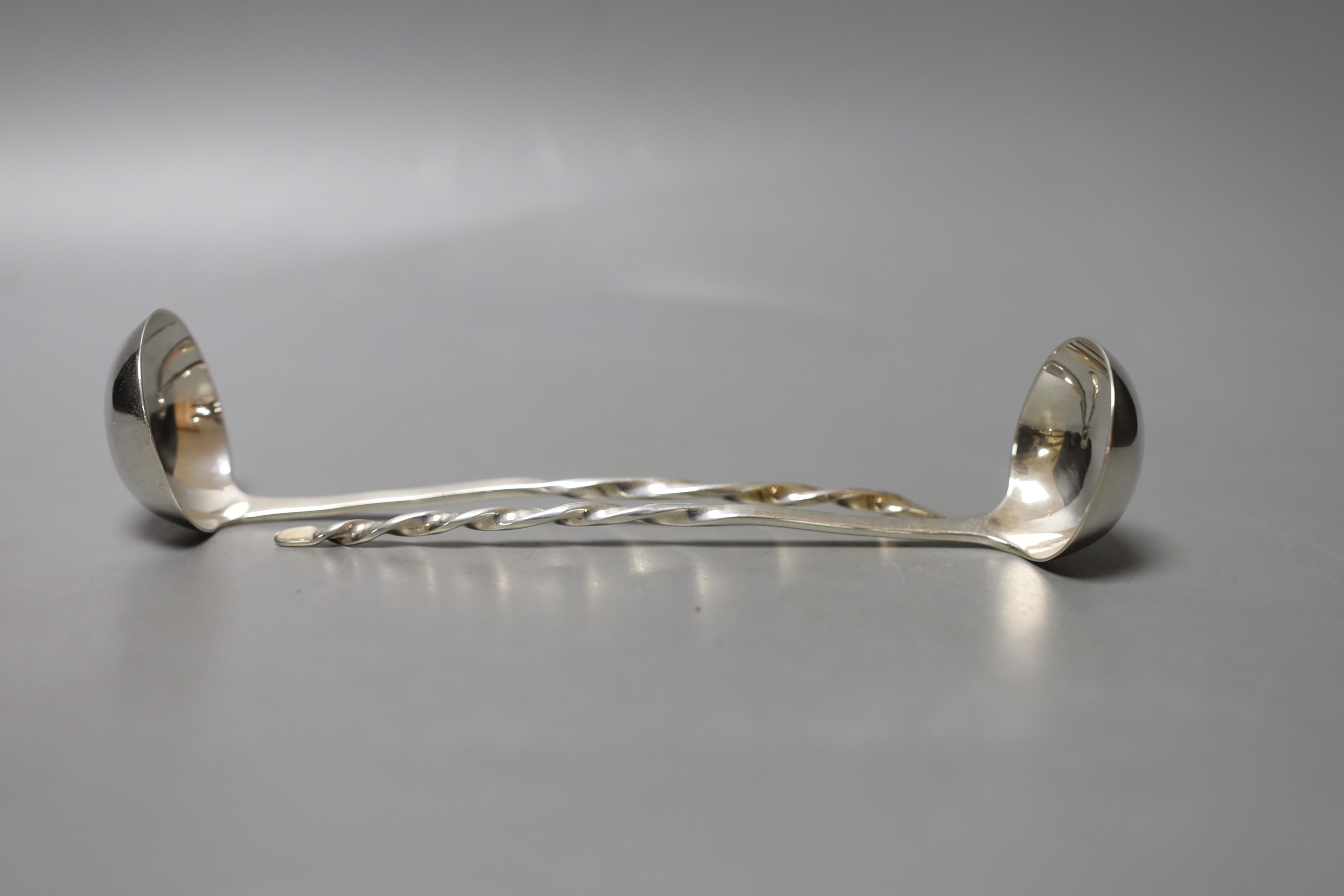 A pair of George III Scottish silver sauce ladles, with spiral handles, Alexander Spence, Edinburgh, 1807, 14.5cm and a pair of George III silver feather edge teaspoons, London, 1782.